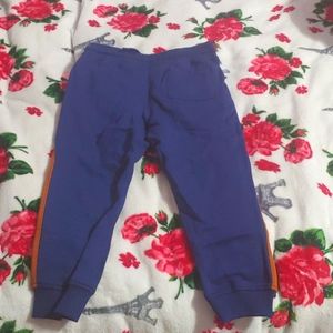 Navy blue jogger sweatpants with orange stripes on the side.